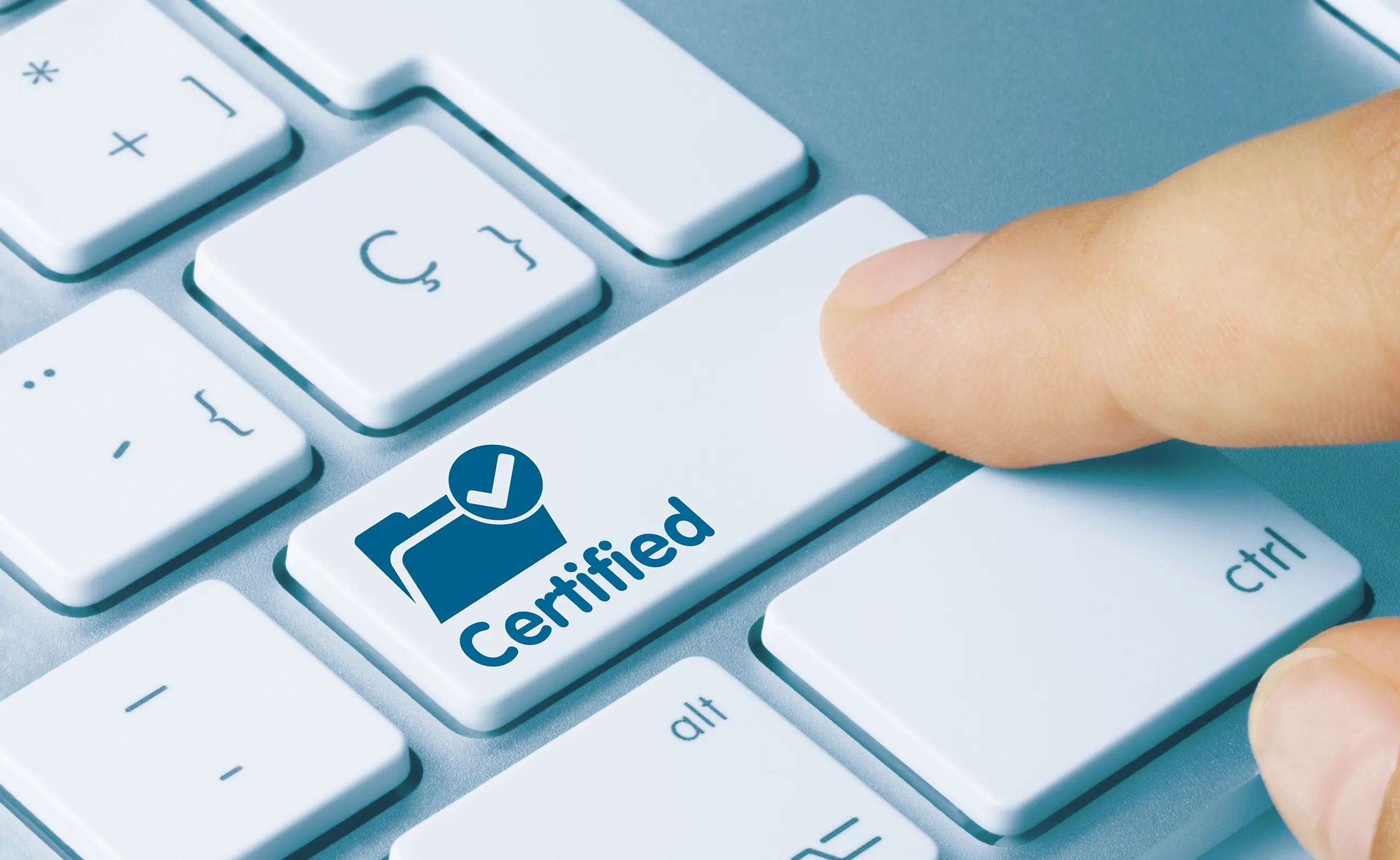 A finger presses a button on a computer keyboard. The button has a folder with a tick and the word ‘certified’ on it. The person pressing the button has plain language certified documents.